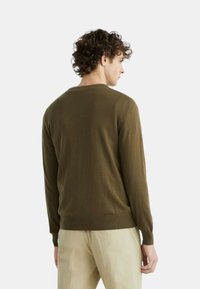 Pullover di maglia verde oliva scuro con collo rotondo, maniche lunghe, polsini a coste e orlo. Tessuto liscio, design aderente senza motivi.