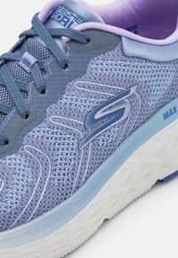 Hellblaue Sportchuhe mit gewobenem Mesh-Obermaterial, verstärkter Zehenkappe, gepolstertem Kragen und weißer strukturiertem Außensohle mit blauen Akzenten.
