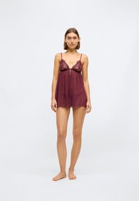 Bordeaux-Lingerieset mit Spitzen-Cups und verstellbaren Trägern. Der durchsichtige Stoff fließt sanft und bietet einen Reißverschluss vorne sowie ein leichtes, luftiges Design.