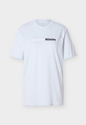 Hvid kortærmet T-shirt med rund hals og "Calvin Klein"-logo i hvidt og sort centreret på brystet, ensfarvet baggrund.
