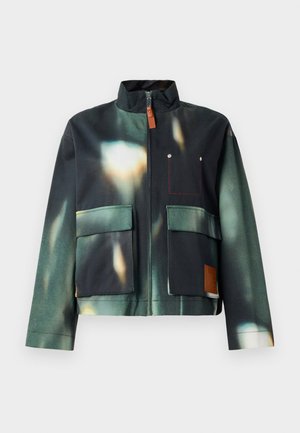 Giacca impermeabile in verde scuro e nero con stampa astratta. Presenta una chiusura con zip, due grandi tasche frontali e un'etichetta in pelle con il marchio.