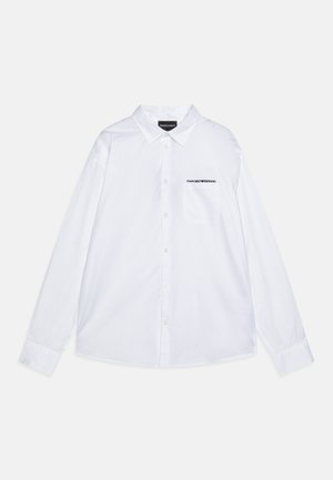 Vit långärmad skjorta i bomull, med klassisk krage, knappframsida, bröstficka till vänster och broderad logga i svart.