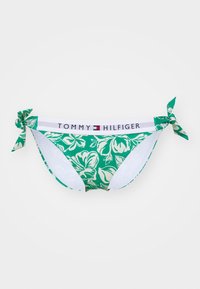Grønn bikinitruse med hvitt blomstermønster, sidesnorer og hvit midjebånd med "TOMMY HILFIGER"-logo i svart og rødt.