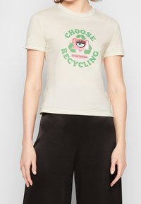 Světlé béžové tričko s krátkými rukávy, kulatým výstřihem a grafickou potiskem "CHOOSE RECYCLING" v zelené a růžové barvě. Hladký bavlněný materiál.