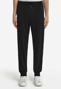 Czarne spodnie dresowe z elastycznym paskiem, dwoma bocznymi kieszeniami, zwężanymi nogawkami i ściągaczami, wykonane z miękkiego, teksturowanego materiału.