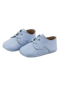 Suaves zapatitos de bebé de cuero azul claro con cordones, que muestran dedos redondeados y suelas suaves, colocados lado a lado sobre un fondo blanco.