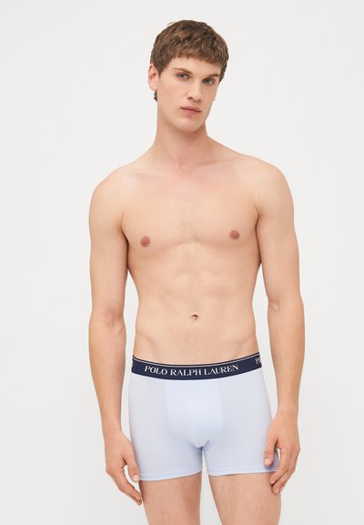 Moški svetlo modri bokserji z mornarsko modrim elastičnim pasom, ki nosi logotip "POLO RALPH LAUREN". Tkanina je gladka z oprijetim dizajnom.