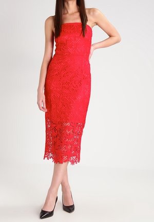 Rode kanten jurk met een aansluitend model en een strapless ontwerp, voorzien van ingewikkelde bloemmotieven en een golvende zoom. Draag zwarte pumps met een spits toelopende neus.