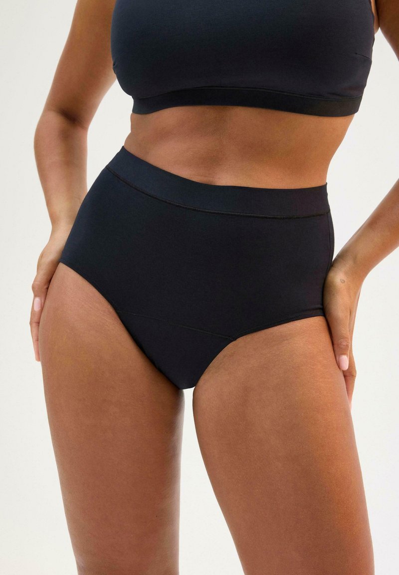 Slip neri a vita alta realizzati in morbido tessuto elasticizzato, con design senza cuciture e una cintura elastica morbida per il massimo comfort.