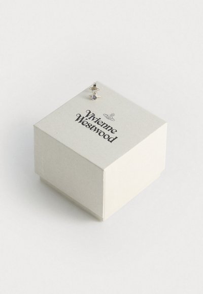 Fehér négyzet alakú ékszerdoboz, textúrált felülettel. A közepén fekete szöveggel olvasható: "Vivienne Westwood", és egy apró ezüst kiegészítő díszíti.
