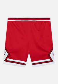 Czerwone sportowe szorty z czarno-białą paskowaną gumką w talii, z kontrastowym białym wykończeniem i czarnymi akcentami oraz detalami logo.