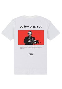 Hvid kortærmet t-shirt med et rødt grafik på ryggen, der viser en figur, der holder et skydevåben, samt tekst på japansk og engelsk ovenfor og nedenfor.