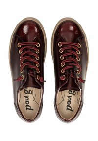 Burgundské lakované tenisky s lesklým povrchem, béžová gumová podrážka, zlaté dírky na šněrování a bordó tkaničky. Viditelné detaily texturovaného povrchu.