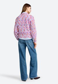 Paars multi-kleurig gebreid vest met lange mouwen, met een losse pasvorm en een textuurpatroon, gecombineerd met hoge taille blauwe denimjeans.