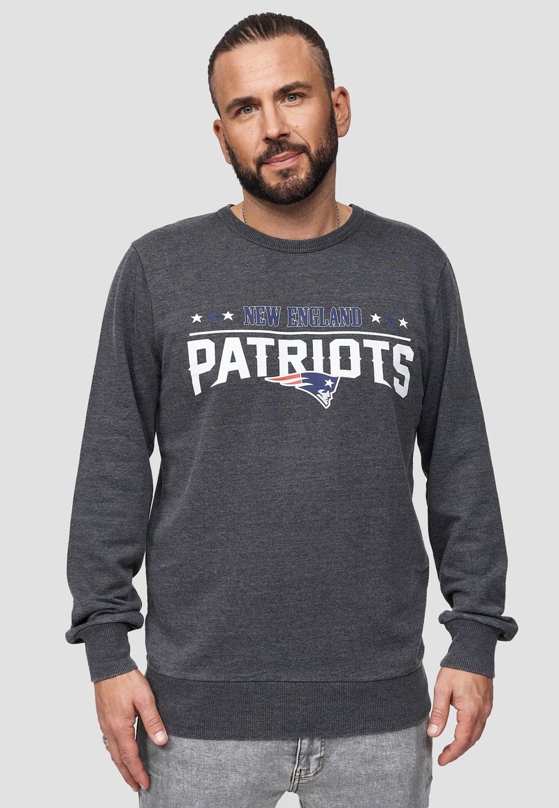Sudadera gris con el texto "New England Patriots" en blanco y azul, de mangas largas, con puños y dobladillo acanalados, fabricada en un tejido suave.