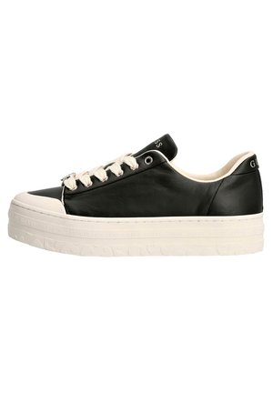 Sneaker in pelle nera con suola in gomma bianca, dotata di lacci decorativi e logo del marchio sul tallone. Design low-top con punta arrotondata.