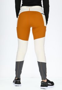 Strakke sportleggings met een kleurblokontwerp in oranje, wit en grijs. Voorzien van ritsen bij de enkels en een hoge tailleband.