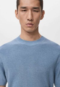 Světlomodrý krátký rukáv svetr z pleteniny s kulatým výstřihem a žebrovanou strukturou. Jednoduchý a bezšvový design, vhodný pro každodenní nošení.