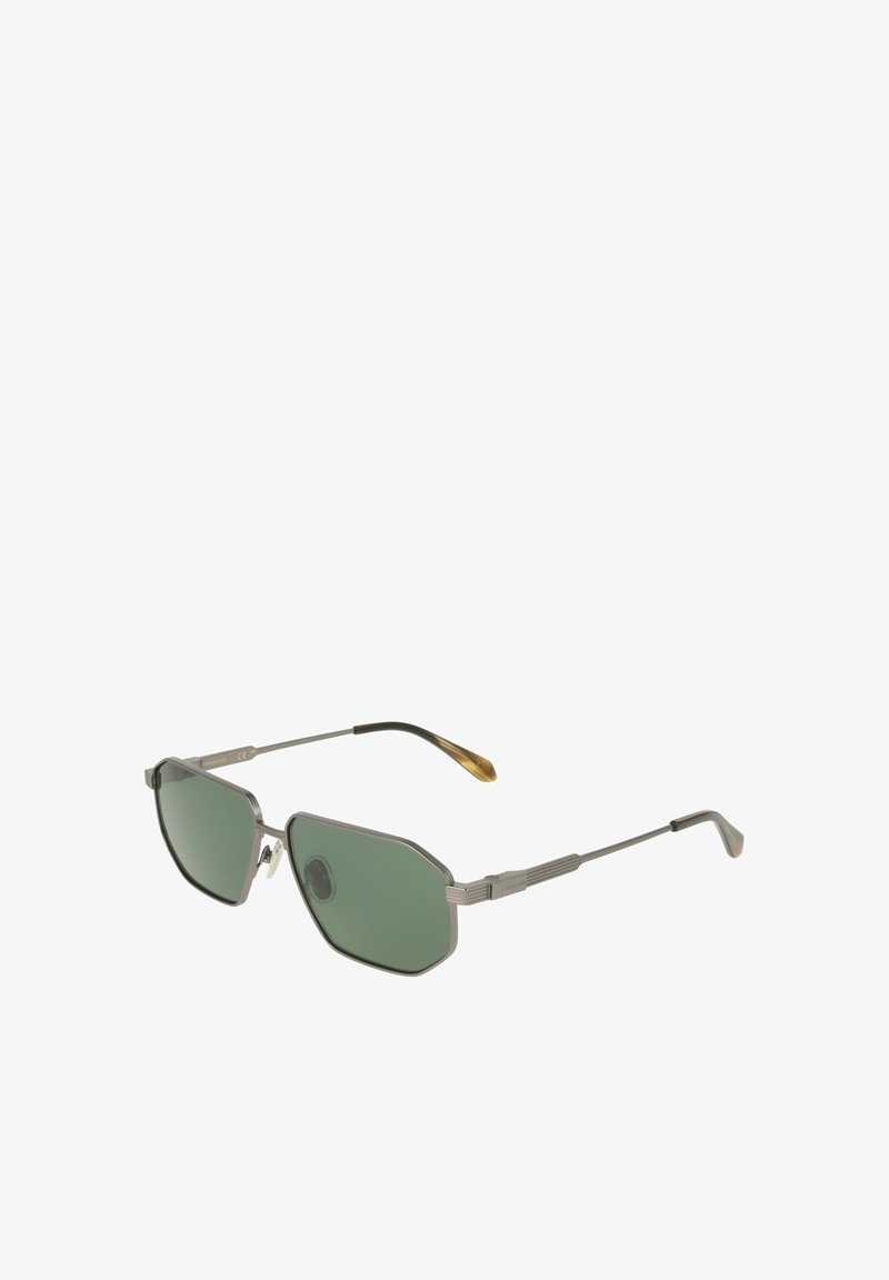 Lunettes de soleil à monture métallique avec des verres octogonaux teintés en vert et des branches fines avec des extrémités marron sur fond blanc.