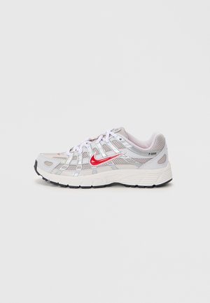 Baskets Nike P-6000 avec une tige en mesh gris, des lacets blancs, un logo rouge, des accents réfléchissants et une semelle en caoutchouc noire.