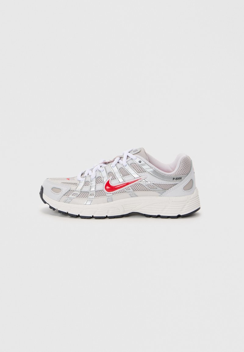 Nike P-6000 tenisice s gornjim dijelom od sive mreže, bijelim čipkastim vezicama, crvenim logotipom, reflektirajućim detaljima i crnim gumenim potplatom.