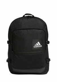 Zaino Adidas nero in tessuto morbido, con tasca frontale con zip, schienale imbottito e patch con logo. Dotato di spallacci regolabili e dettagli in rete.