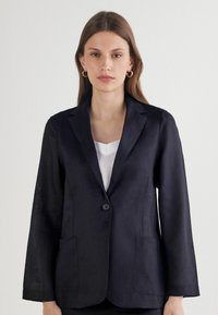 Granatowa marynarka wykonana z lnu, z pojedynczym guzikiem, dwoma przednimi kieszeniami oraz usztywnioną konstrukcją z długimi rękawami.