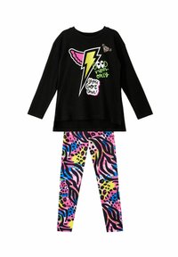 Zwarte lange mouwen shirt met kleurrijke bliksemafbeelding en tekst, gecombineerd met levendige legging met abstract dierenprint in roze, blauw en groen.