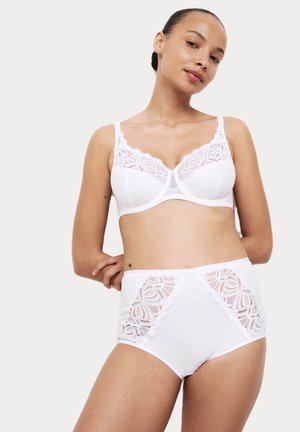 Witte lingerie set met een bh met kantdetails en een stippenpatroon, gecombineerd met hoog gecapitonneerde slipjes met bijpassende kantaccenten.