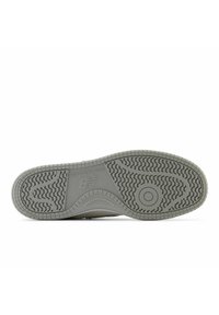 Gray rubber sole with a patterned tread, featuring textured grooves and the New Balance logo embossed on the lateral side.