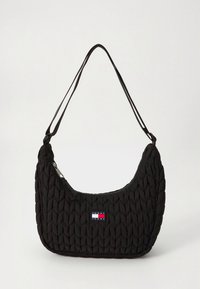 Fekete steppelt válltáska lekerekített formával, cipzáras záródással és egy kis piros, fehér, kék logófolttal. Simább tapintású felület.