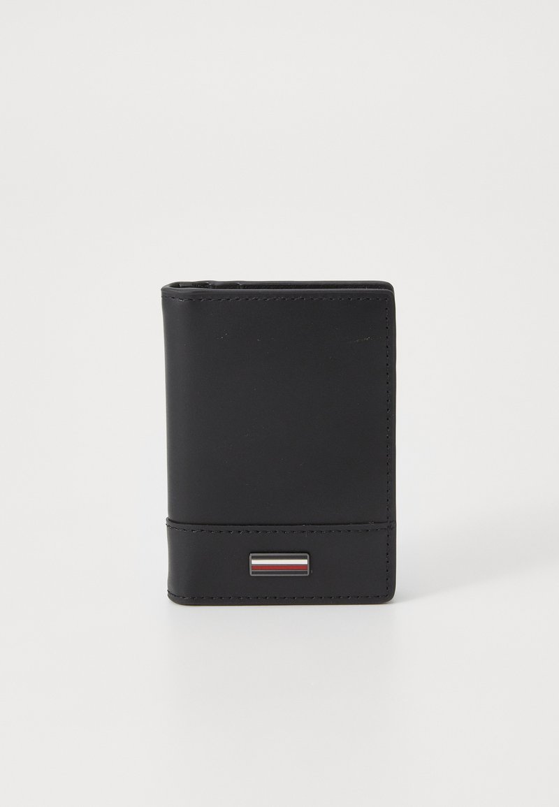 Portefeuille en cuir noir de forme rectangulaire, avec un petit accent en métal orné de bandes rouges, blanches et bleues sur le devant.