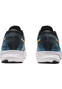 Scarpe da corsa con tomaia in maglia nera e blu, accenti arancioni e intersuola bianca. La vista posteriore mostra un materiale testurizzato e una forma arrotondata.