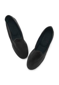 Zapatos de tela negros tipo slip-on con una textura suave, puntera redondeada y bordes cosidos. El interior presenta un forro suave y oscuro.