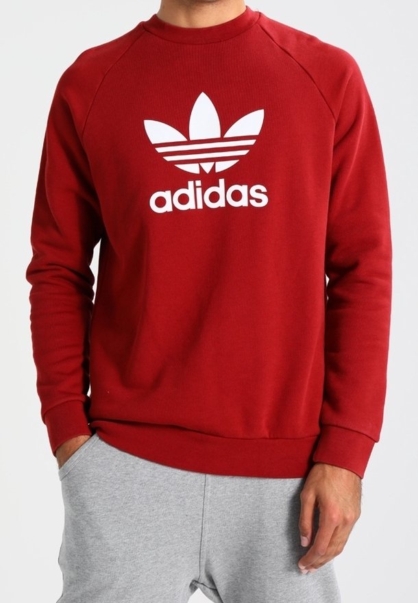 Červená bavlněná mikina s kulatým výstřihem, žebrovanými manžetami a velkým bílým logem Adidas se klasikými třemi pruhy.