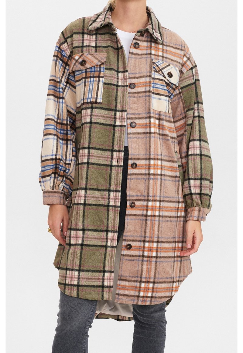 Ruudullinen paitatakki vihreän, beigen ja oranssin sävyissä. Valmistettu teksturoidusta kankaasta, siinä on kaksi rintataskua ja napilliset sulkimet.