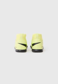Neon žluté sportovní boty s vysokým designem, černými akcenty, texturovanými podrážkami a zesílenou patou pro větší podporu.