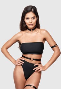 Schwarzes Bikini-Set mit einem Bandeau-Oberteil, hoch taillierten Bottoms und verstellbaren Trägern mit Ringakzenten. Glatte Textur mit minimalistischer Gestaltung.