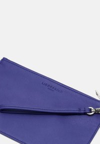 Fioletowy skórzany portfel o teksturowanej powierzchni, z metalowym zamkiem i paskiem na nadgarstek. Nazwa marki "LIEBESKIND" jest wytłoczona na zewnątrz.