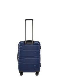 Valigia rigida navy con scanalature testurizzate, manico retrattile, quattro ruote e manico laterale per un facile trasporto.