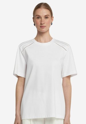 Witte katoenen t-shirt met korte mouwen, voorzien van geperforeerde details op de schouders en een ronde hals. Harde textuur en een ontspannen pasvorm.