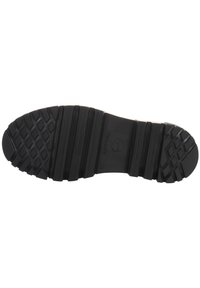 Semelle de chaussure noire avec une texture crantée, comprenant des motifs en losange et des rainures horizontales pour une meilleure adhérence et stabilité.