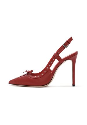 Chaussure à talon haut en cuir rouge avec bout pointu, détail de nœud et clous en argent le long du bord. Texture lisse et sangle ajustable.