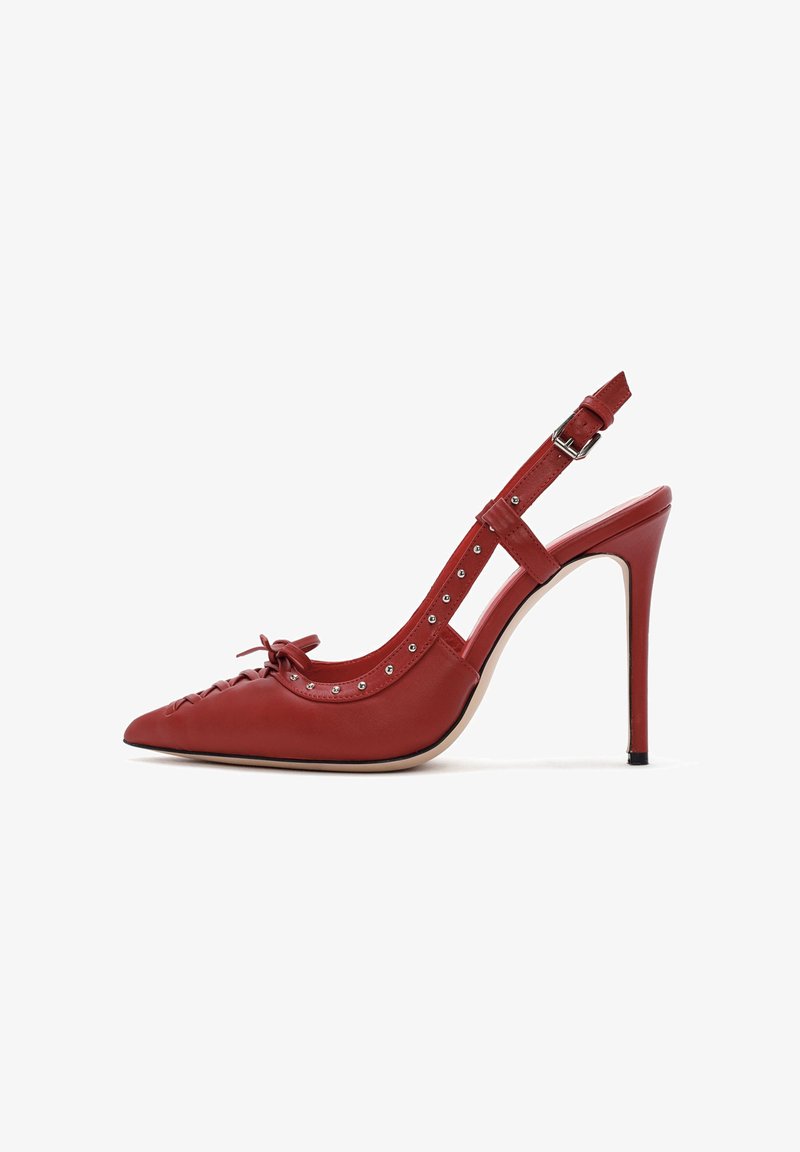 Red leather high-heeled slingback shoe with pointed toe, bow detail, and silver studs along the edge. Smooth texture and adjustable strap.