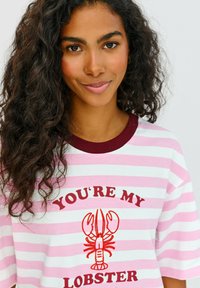 Bílý a růžový pruhovaný tričko s bordovým žebrovaným límečkem, zdobené grafikou červeného humra a textem "TY JSI MŮJ HUMR."