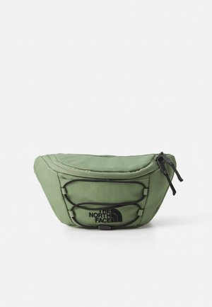 Grøn stof talletaske med lynlåslukket hovedrum, forreste elastiksnor og sort logo "The North Face" på frontlommen.