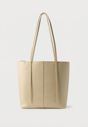 Beige lædertaske med to lange skulderstropper og en enkel lodret søm ned langs midten.