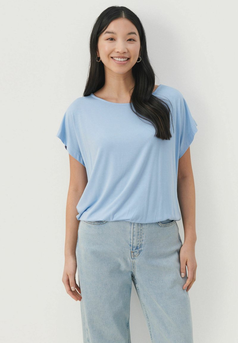 Lyseblå kortærmet bluse med en afslappet pasform og rund hals. Bæres med lyse, vide jeans med en glat tekstur.