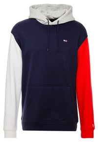 Sudadera con capucha de color gris en la capucha, cuerpo en azul marino y mangas en rojo y blanco. Presenta un bolsillo frontal y un pequeño logo en el pecho.