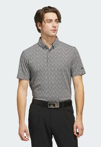 Short-sleeve polo shirt in gray with a subtle striped pattern, featuring a collared neckline and button placket. Worn with black trousers and belt.
